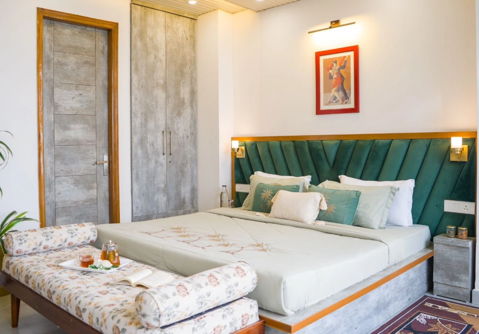 Stylish hotel bedroom with plush double bed, upholstered headboard, warm lighting, modern wardrobe, and elegant décor